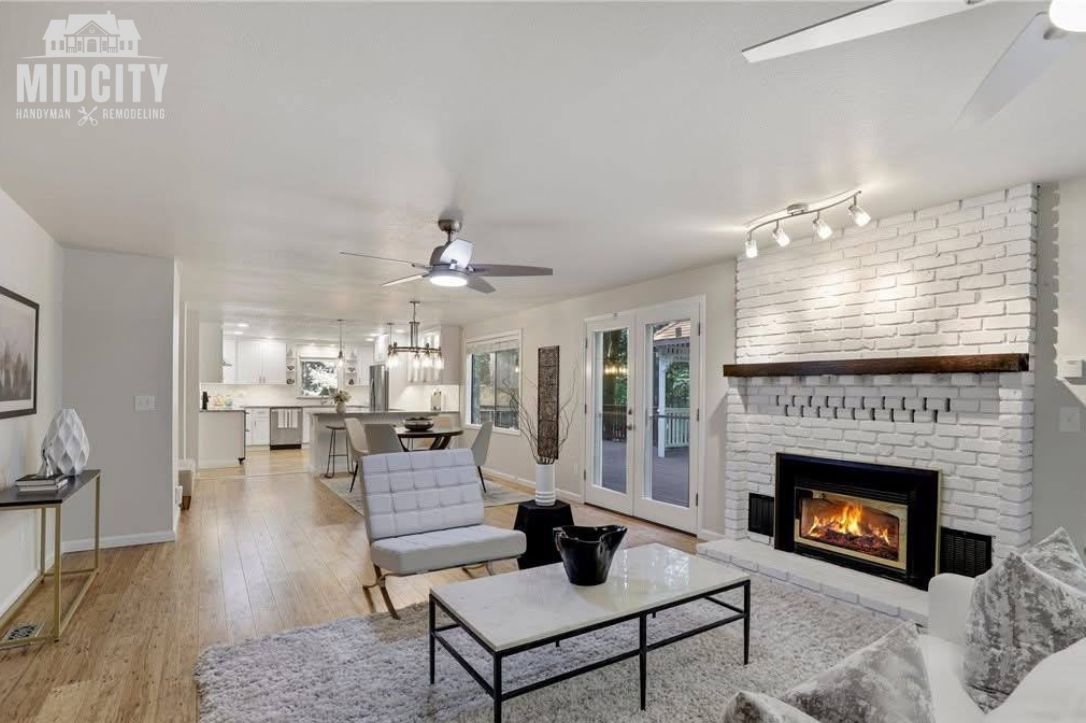 Bright open concept living space with fireplace after remodeling by Midcity Handyman & Remodeling